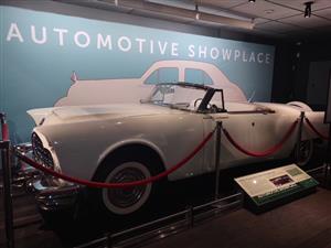 a old model car behind a velvet rope